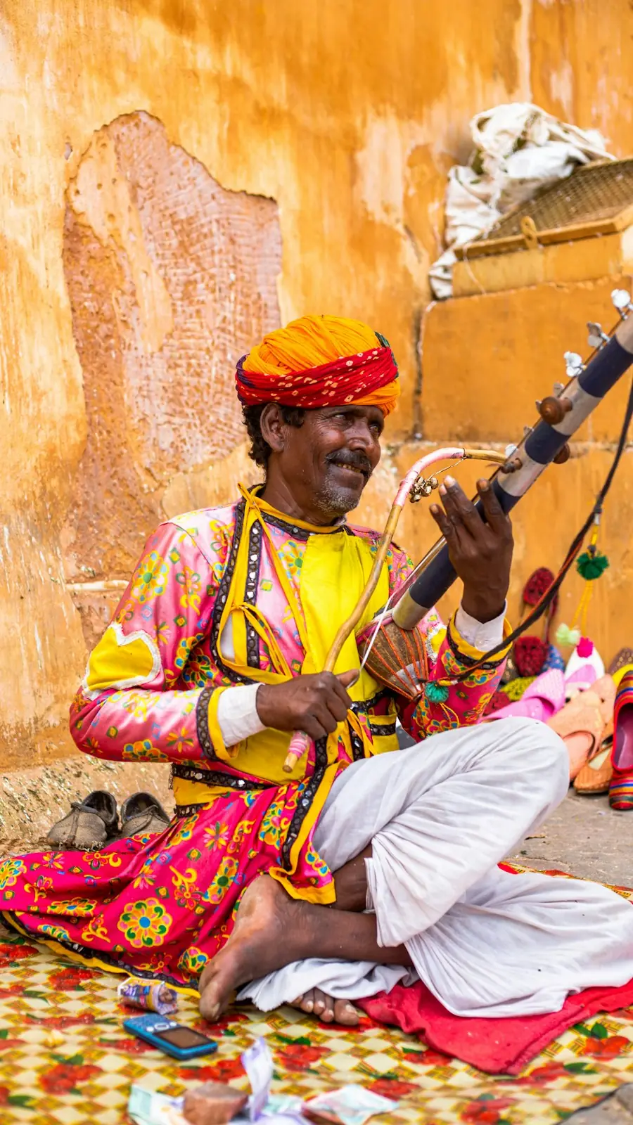 A musician in a bright turban playing a traditional string instrument